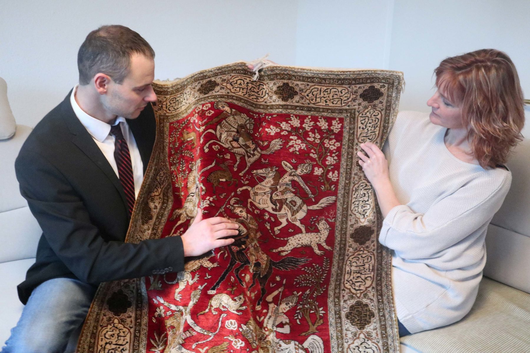 Daniel Neff talking to a client about an antique carpet